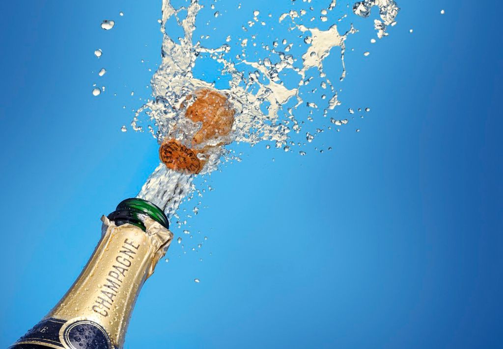 Korken spretter på en flaske champagne. Foto.