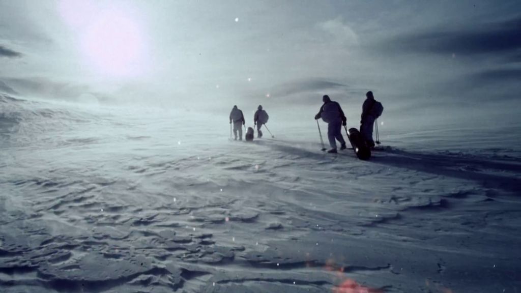 Fleire skikkelsar på ski over eit aude snølandskap. Foto.