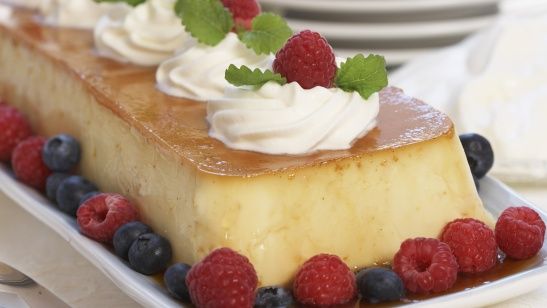 Karamellpudding med krem og bær. Foto.
