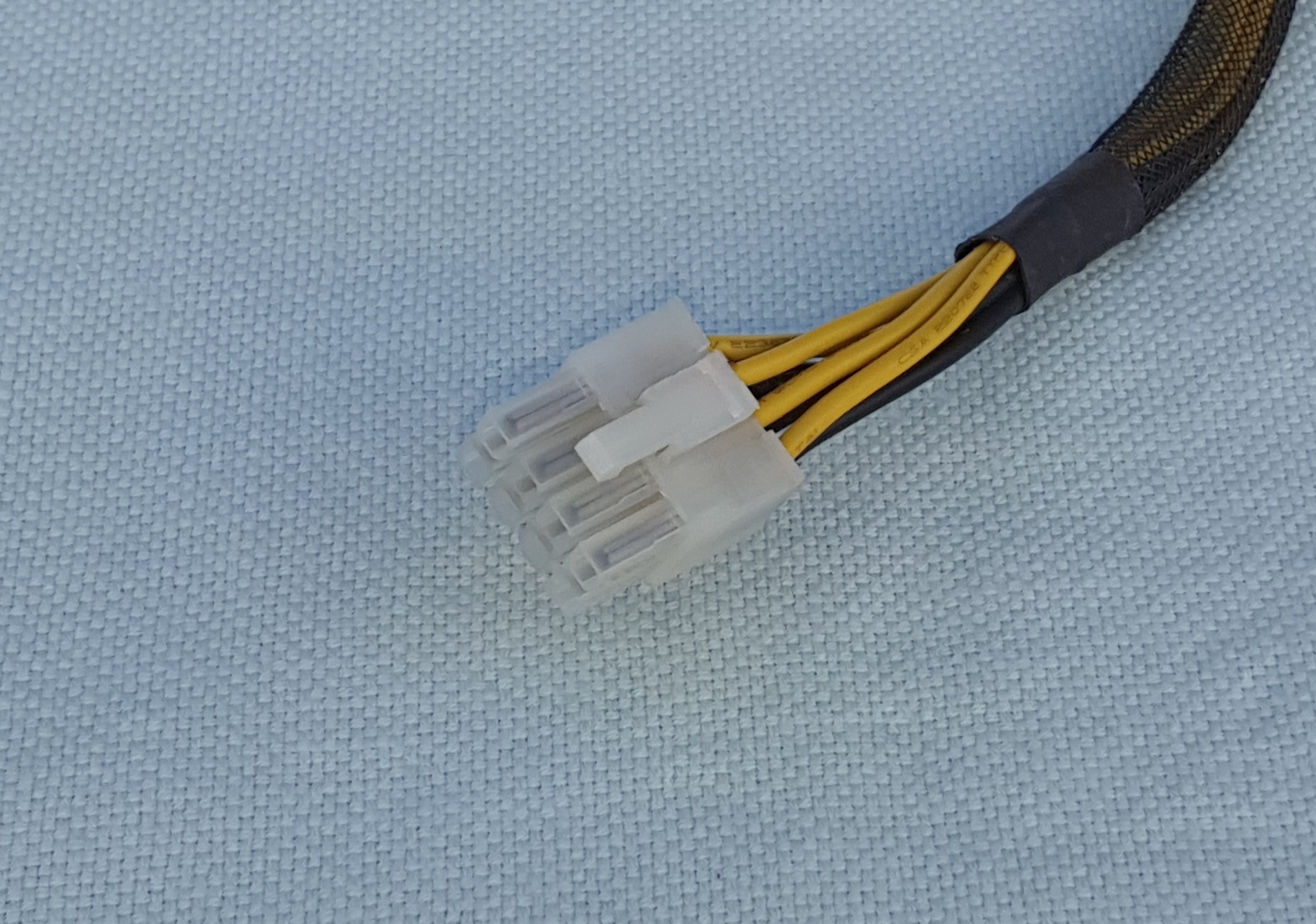 Hannkontakt som har to rader med fire pinner i hver rad. Den har også en plastbit som låser kontakten på plass i holderen. Foto.