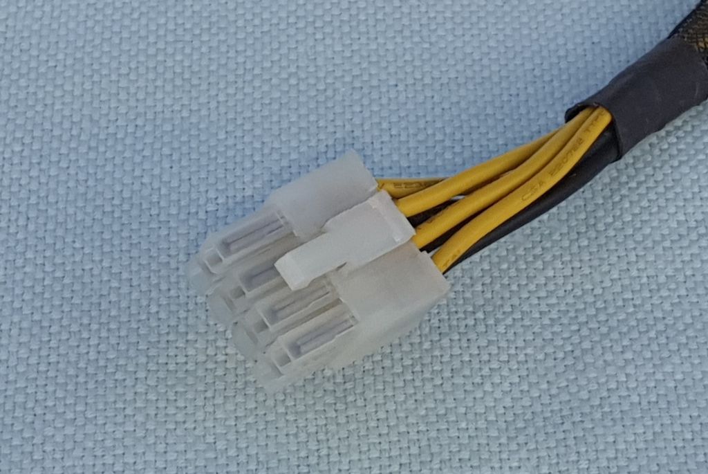 Hannkontakt som har to rader med fire pinner i hver rad. Den har også en plastbit som låser kontakten på plass i holderen. Foto.