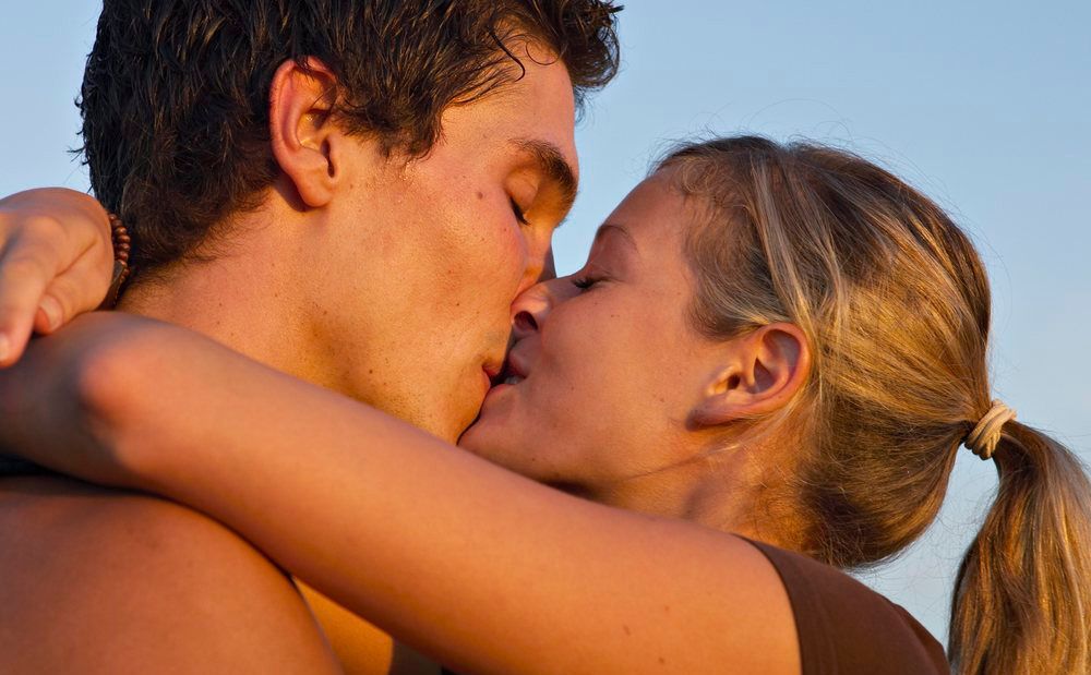 Ungt par som kysser. Foto. 