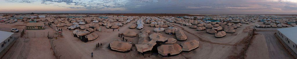 A panorama photo of a refugee camp filled with tents.