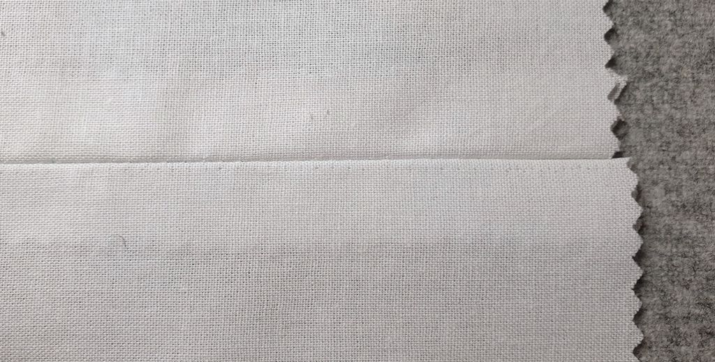 Fotografi av prøvelapp med presset rettsøm, sett fra rettsida.