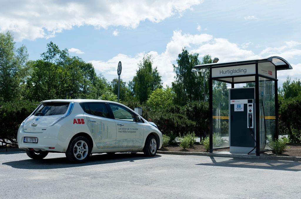 Elbil parkert ved siden av hurtigladestasjon. Foto.