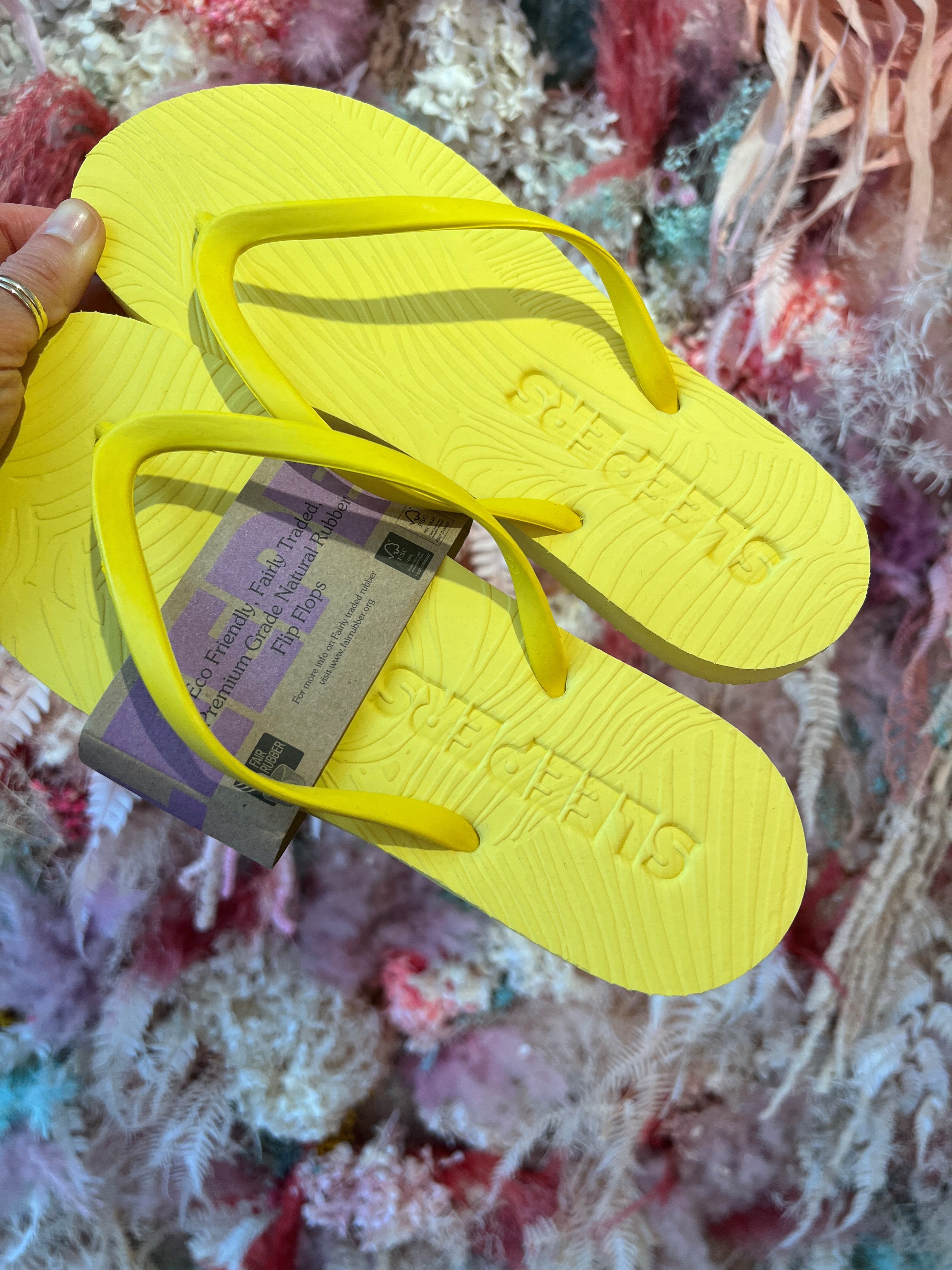 Et par gule slipperser av merket Sleepers. Foto.