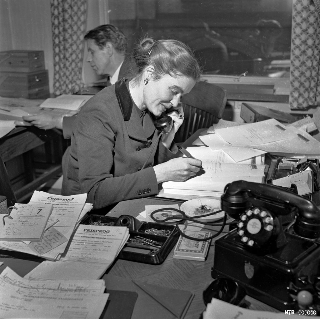 Kvinnelig representant for Foreldreaksjonen mot samnorsk tar imot telefonhenvendelser mens hun skriver på et ark. Foto.