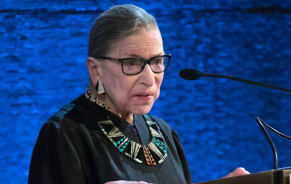 Ruth Bader Ginsburg standing behind a microphone. Photo.
