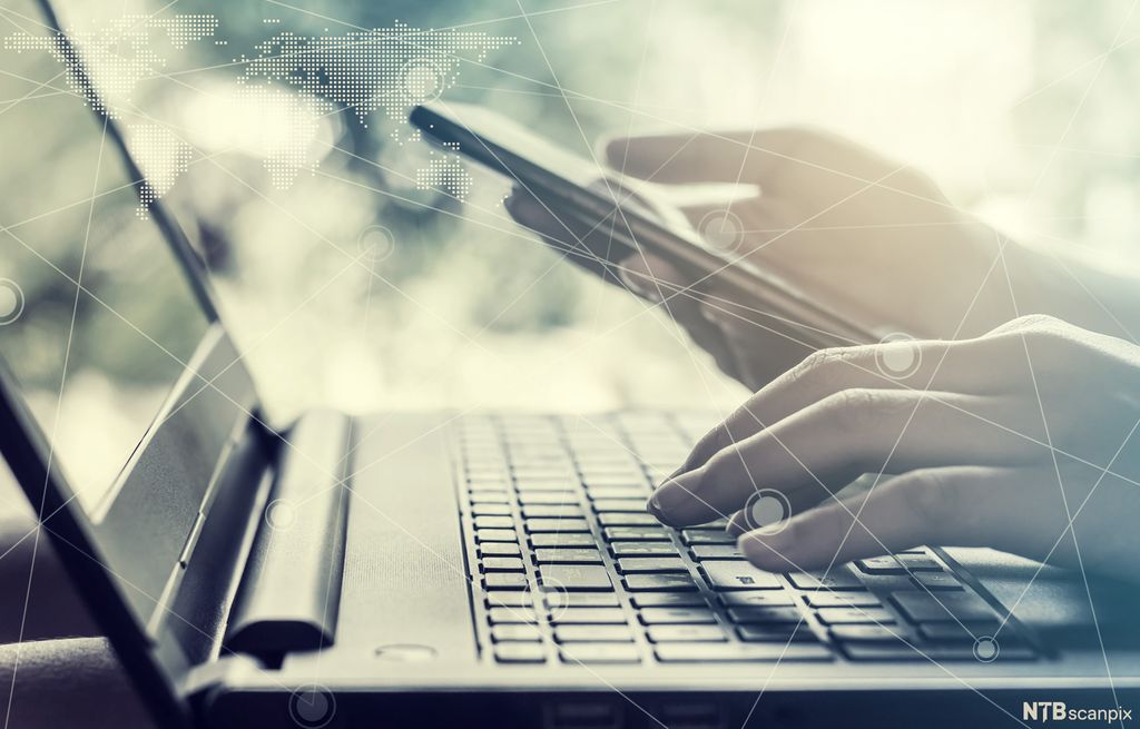  Fingre over PC og mobiltelefon. Foto.