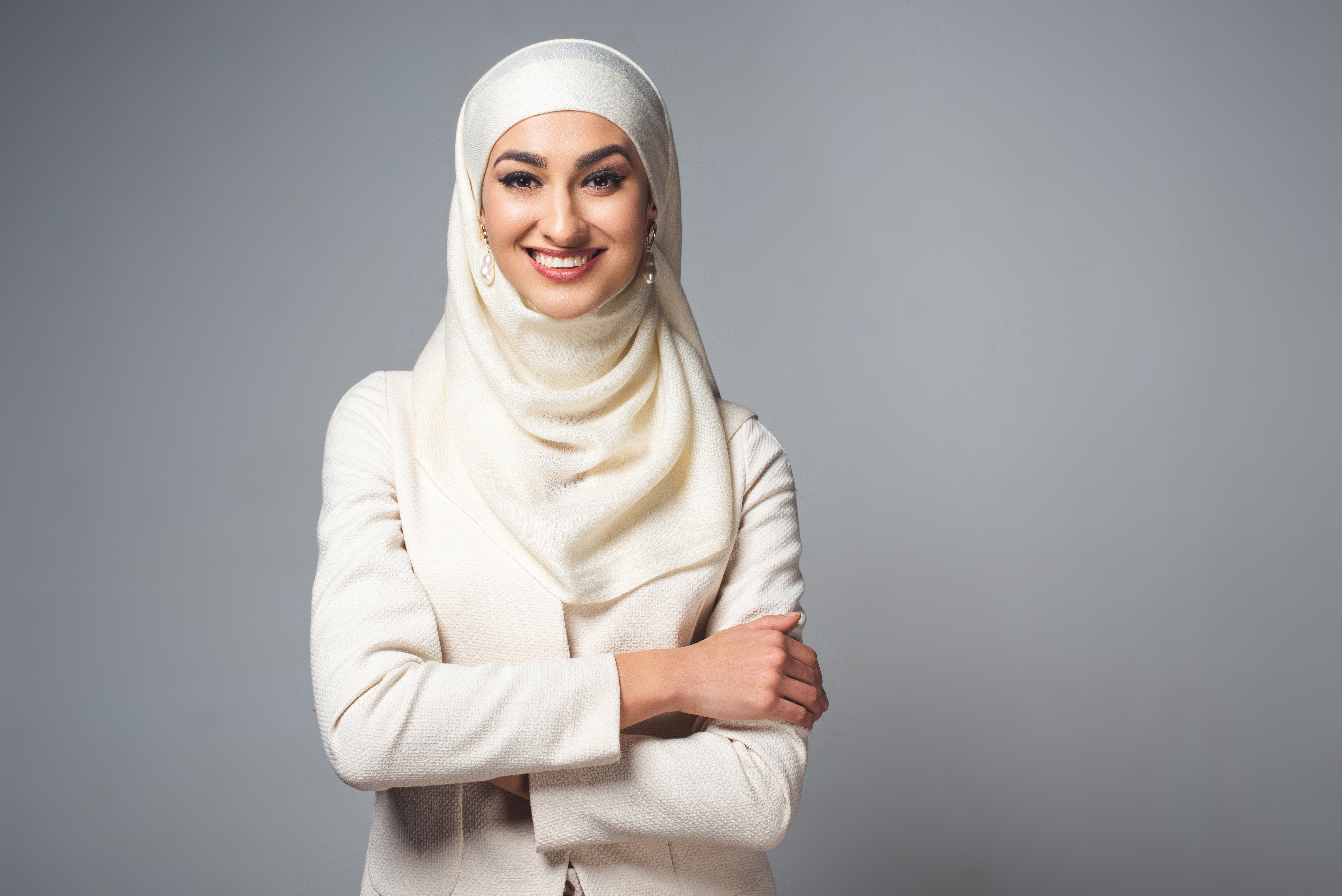 Halvnært utsnitt av ei smilende ung dame med hijab. Foto.