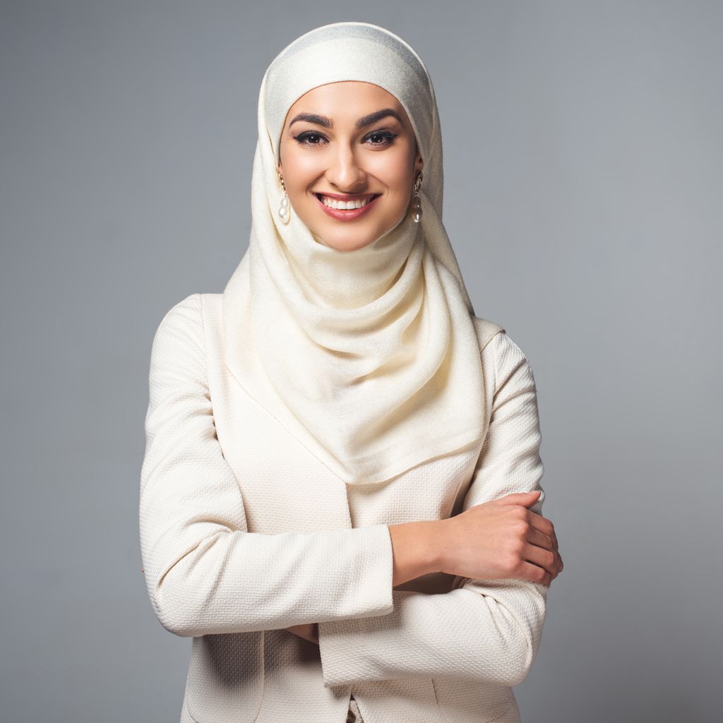 Halvnært utsnitt av ei smilende ung dame med hijab. Foto.
