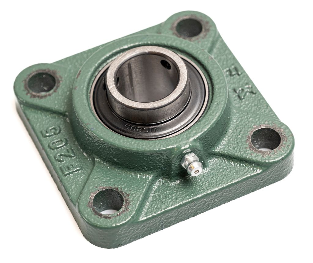 Metallager med et festehull i hvert av de fire hjørnene og et hull i midten for en aksling. Foto.