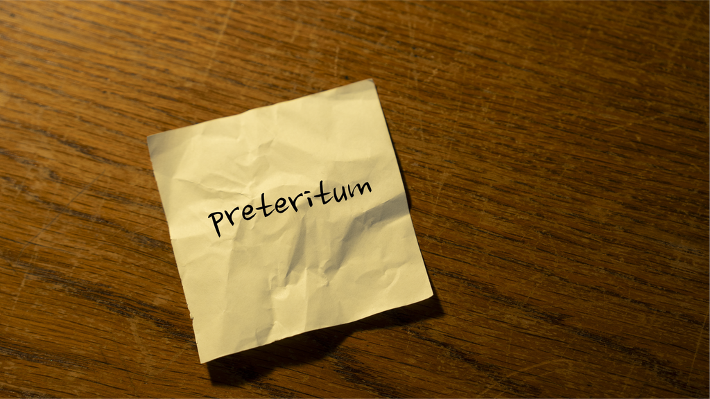 Lapp der det står "preteritum". Foto.