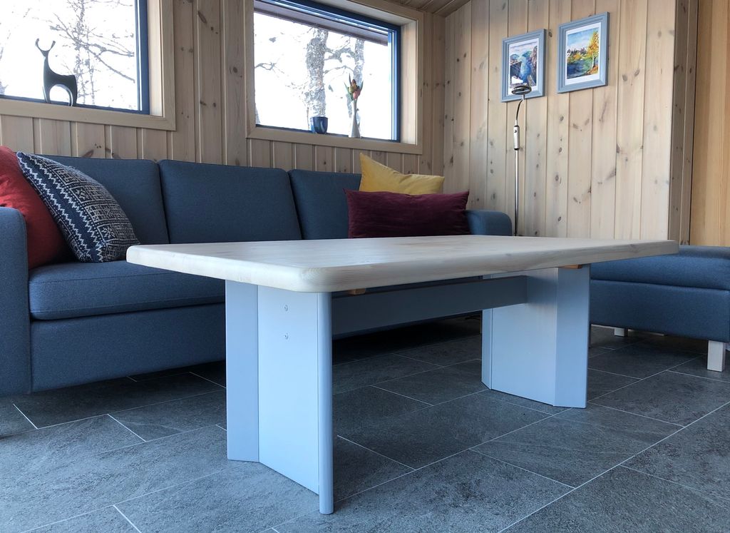 Hytteinteriør: sofa og bord. Foto.