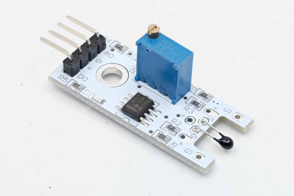 Printplate med elektroniske komponenter montert. Fire tilkoplingspunkter. Foto.