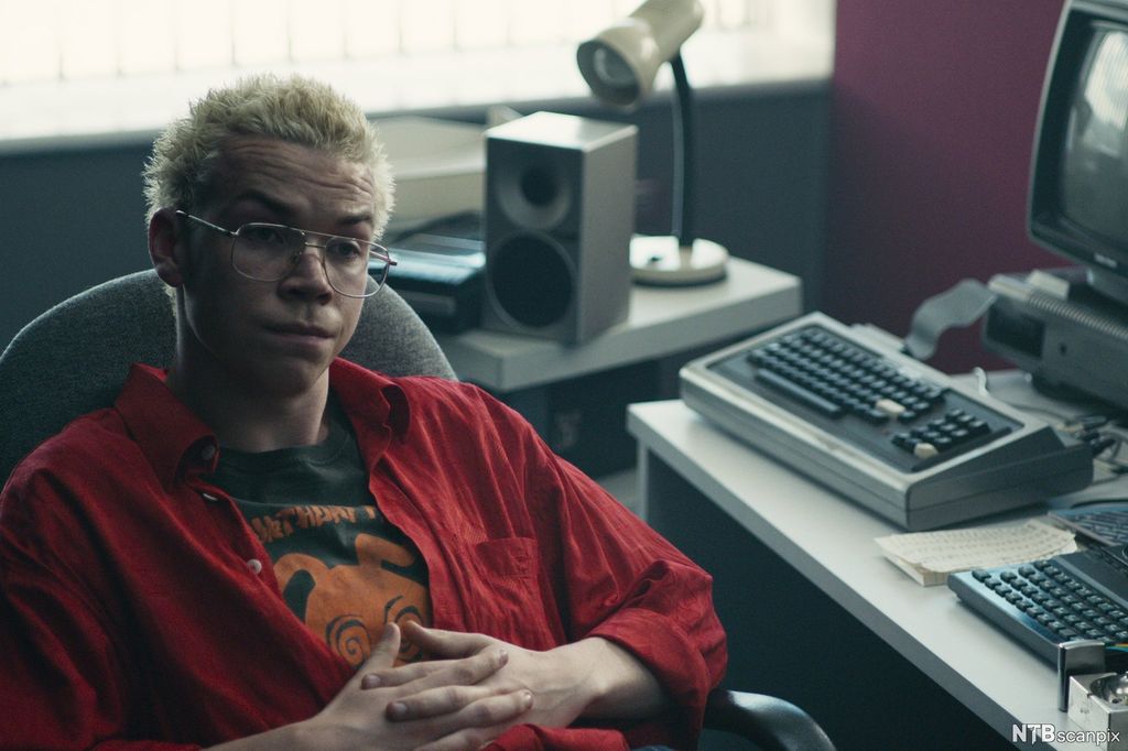 Skodespelar Will Poulter i stol ved eldre datamaskin. Foto.