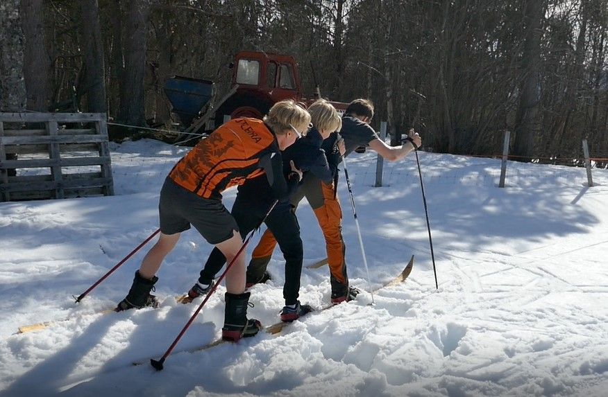 Tre unge menn står på ski på det samme skiparet. Foto.