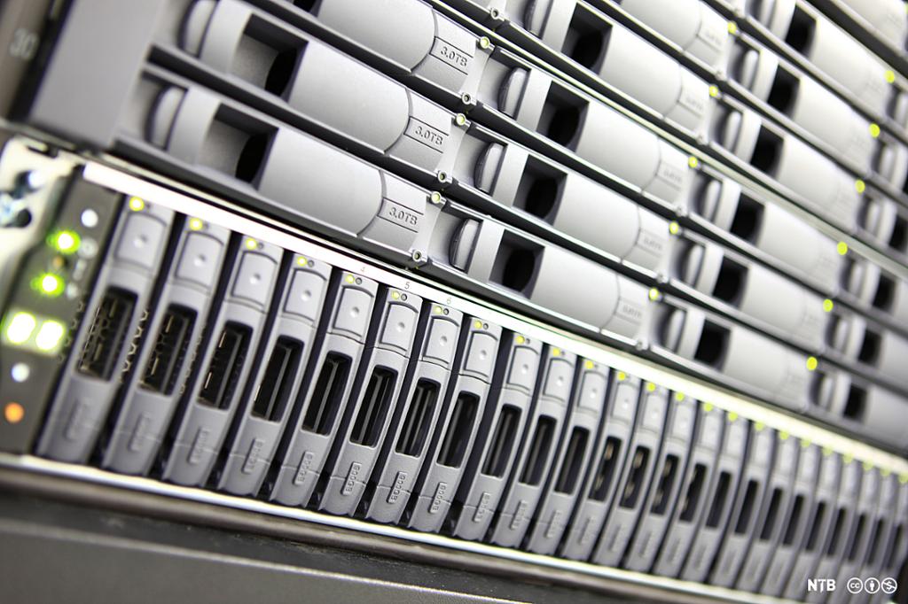 En mengde harddisk skuffer i fronten av rack servere. Foto.