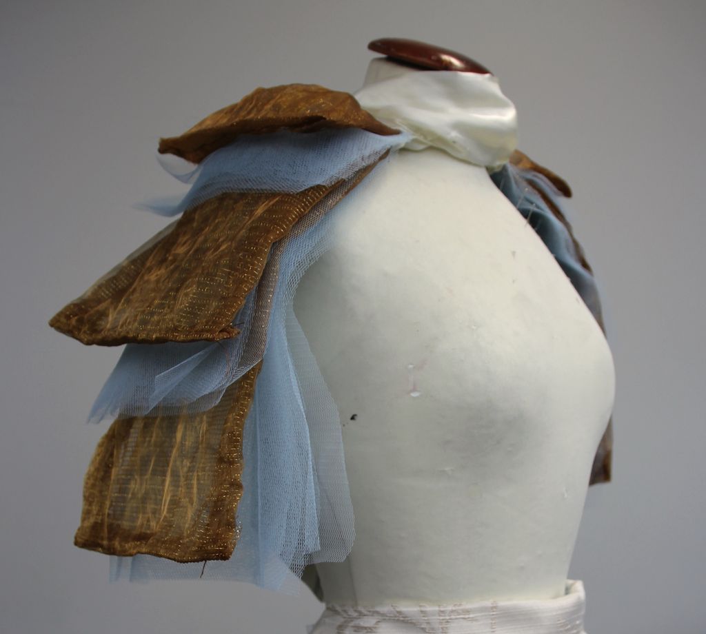 Tekstiler i flere lag montert på en byste. Foto.