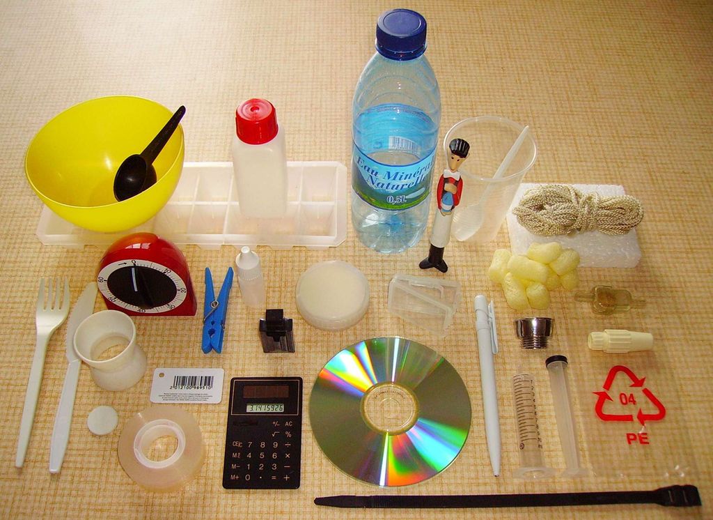 Dagligdagse gjenstander på ei flate, deriblant cd, penn, sprøyte, isoporbiter, kalkulator, teiprull, plastbestikk, klesklype, timer, vannflaske, måleskje, taukveil og isbitbrett. Foto.