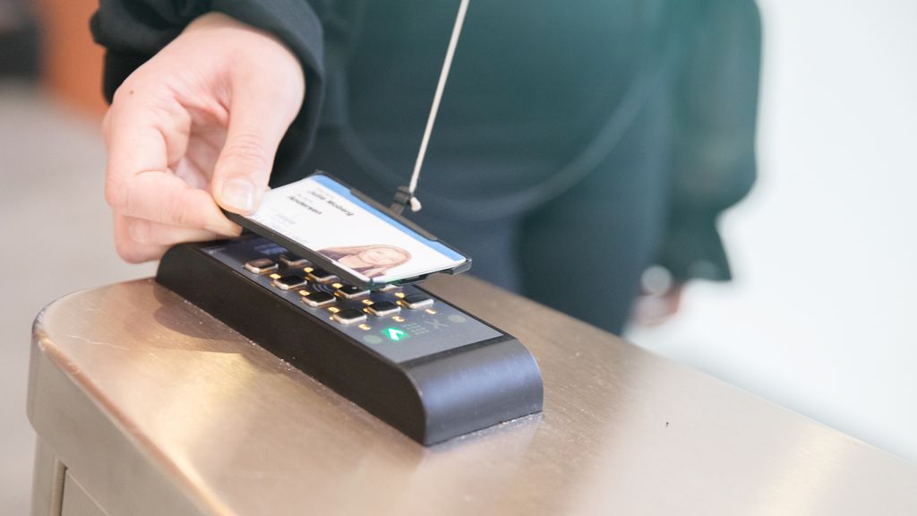 En person skanner adgangskortet sitt. Foto.