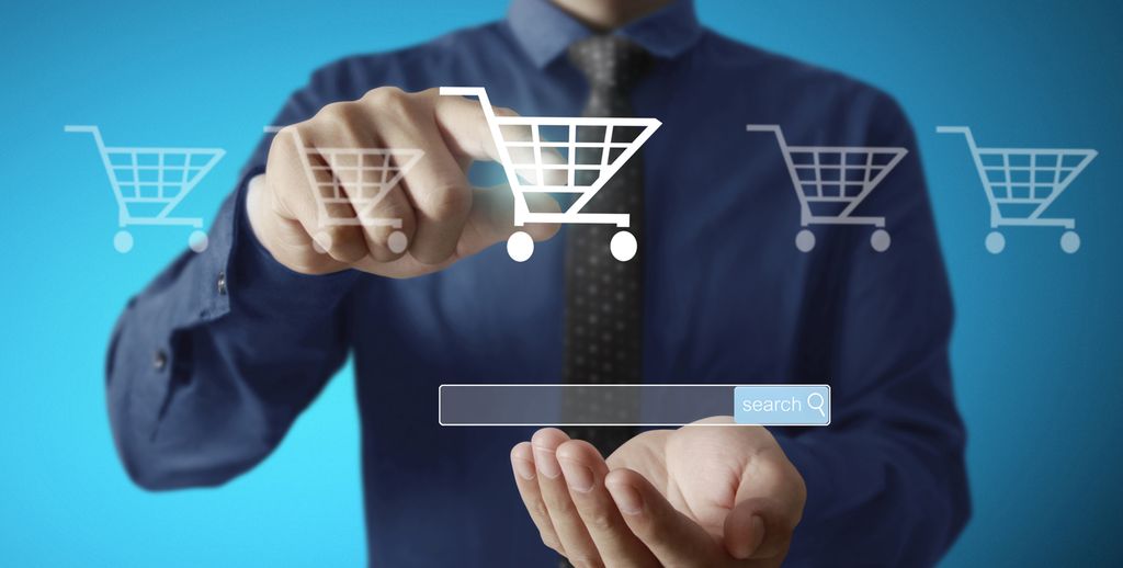 Ein ung mann trykkjer på eit av fleire handlevogn-ikon ved eit søkjefelt på ein skjerm. Illustrasjon.