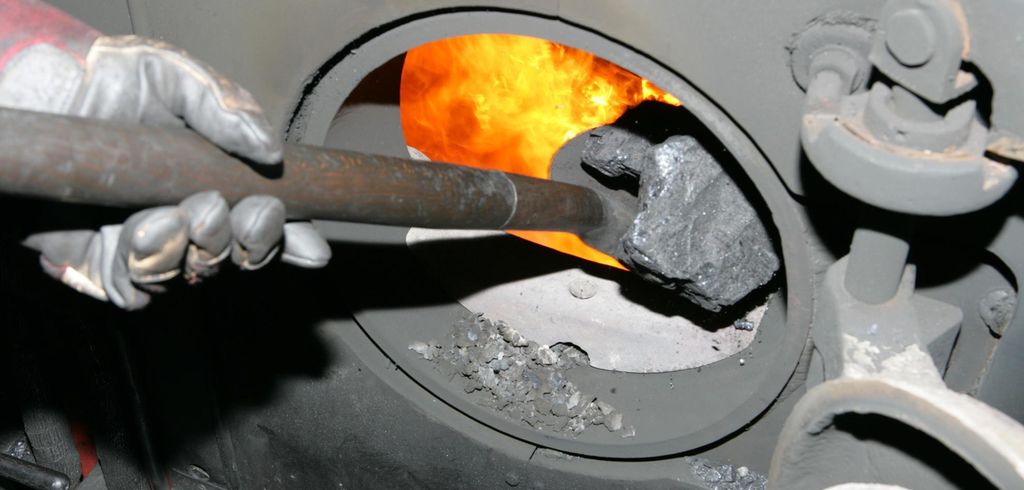 Kull blir lastet inn i en ovn med en spade. Foto.