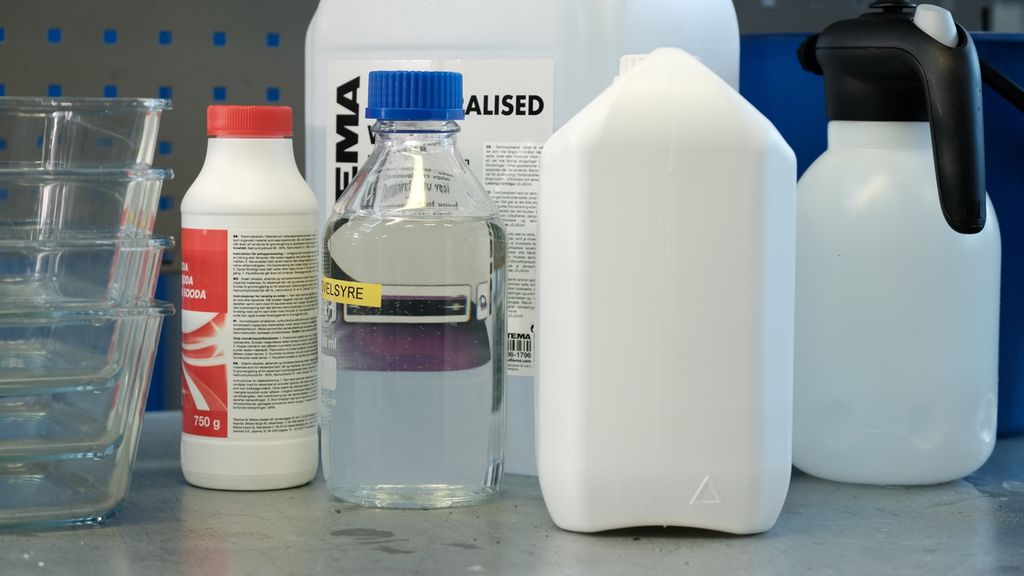 Plast- og glassbeholdere på en arbeidsbenk. Foto.