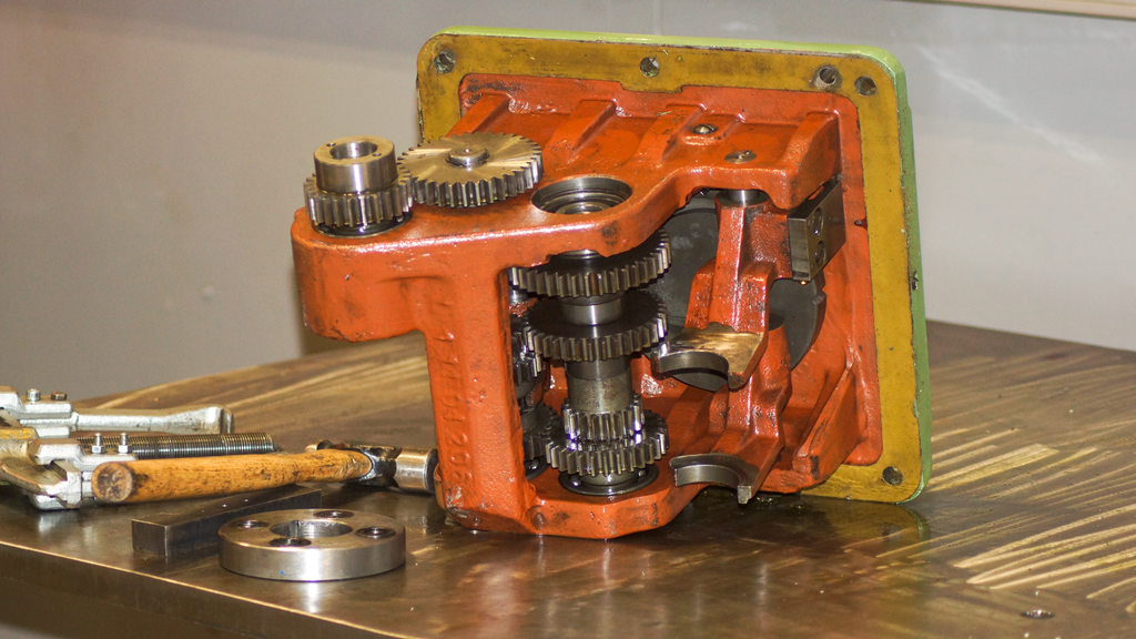 Demontert girboks plassert på et arbeidsbord sammen med verktøy. Foto.