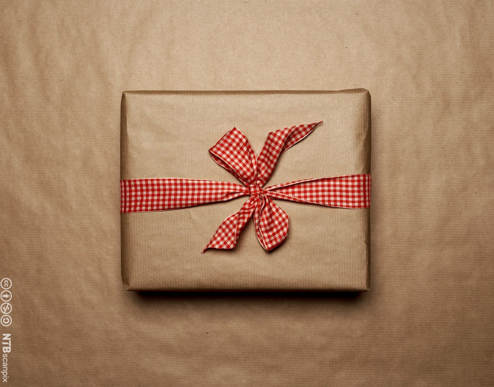 Photo: Gift wrapped in brown paper. It has a red and white bow. 