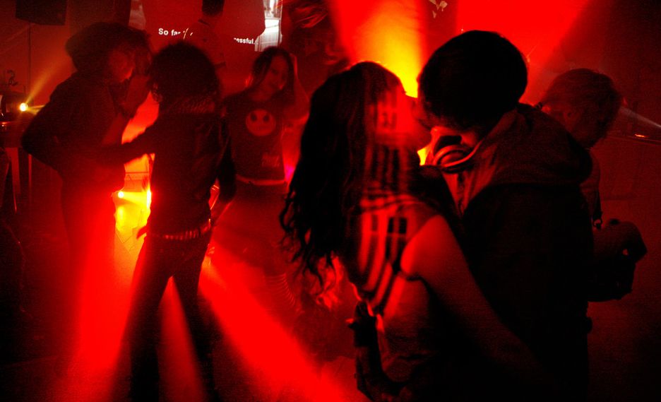 Foto av ungt par som kysser på dansegulvet. 