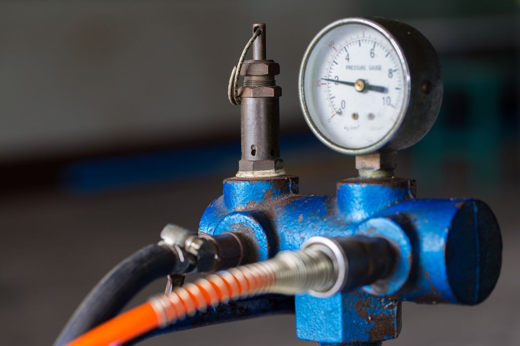 Måler på en stempelluftkompressor brukt på fabrikk. Foto.