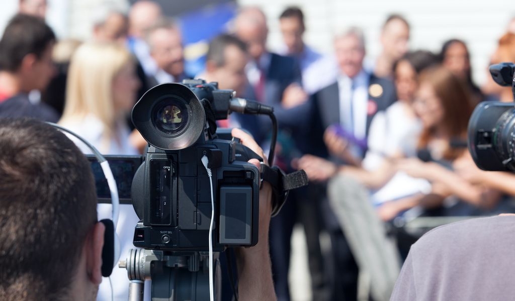 Journalister og fotografer på jobb, en fotograf gjør opptak av intervju. Foto.
