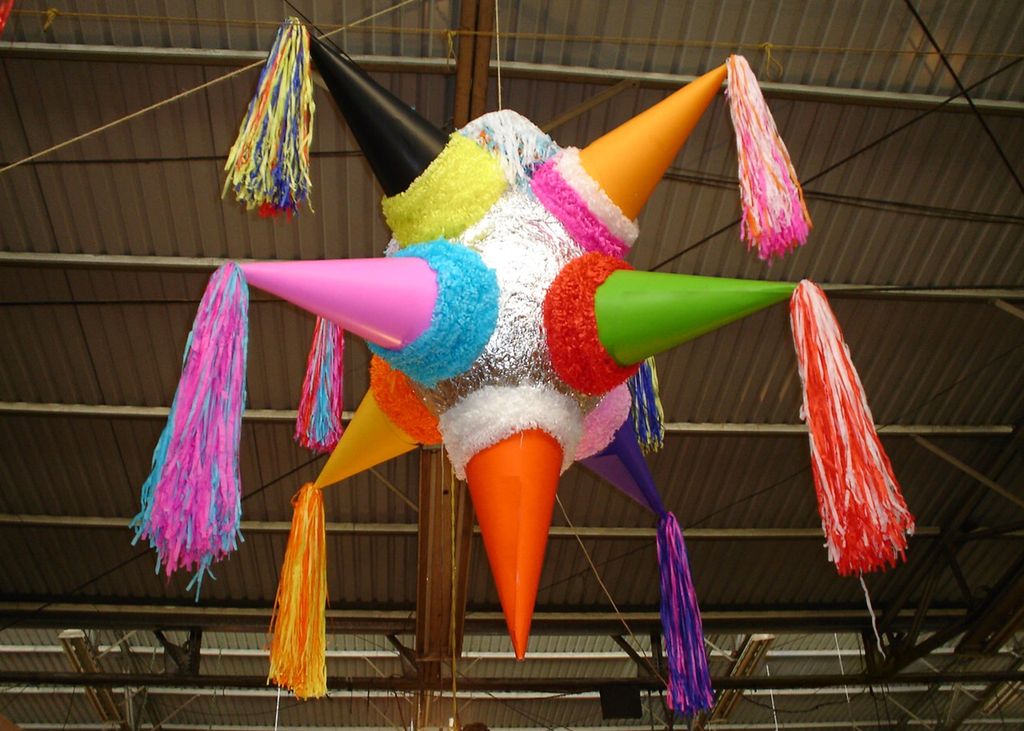 En fargerik piñata som henger fra et tak. Foto.