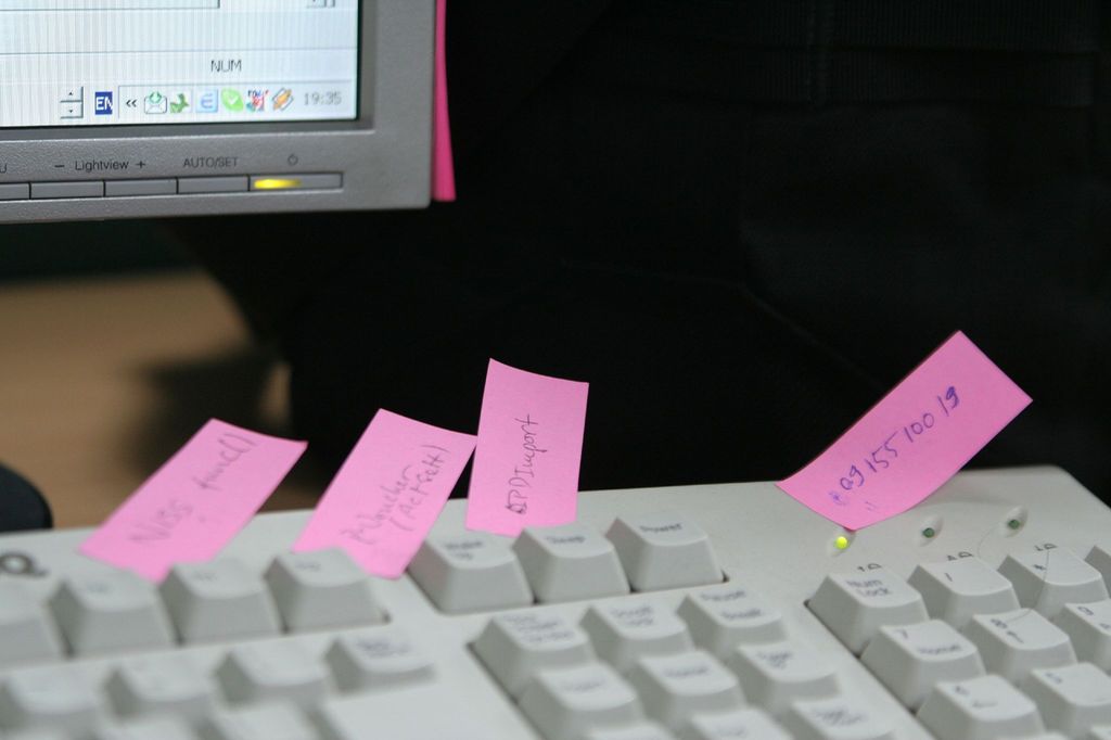 Et tastatur som det er klistret små rosa lapper med tekst og tall på. Foto.