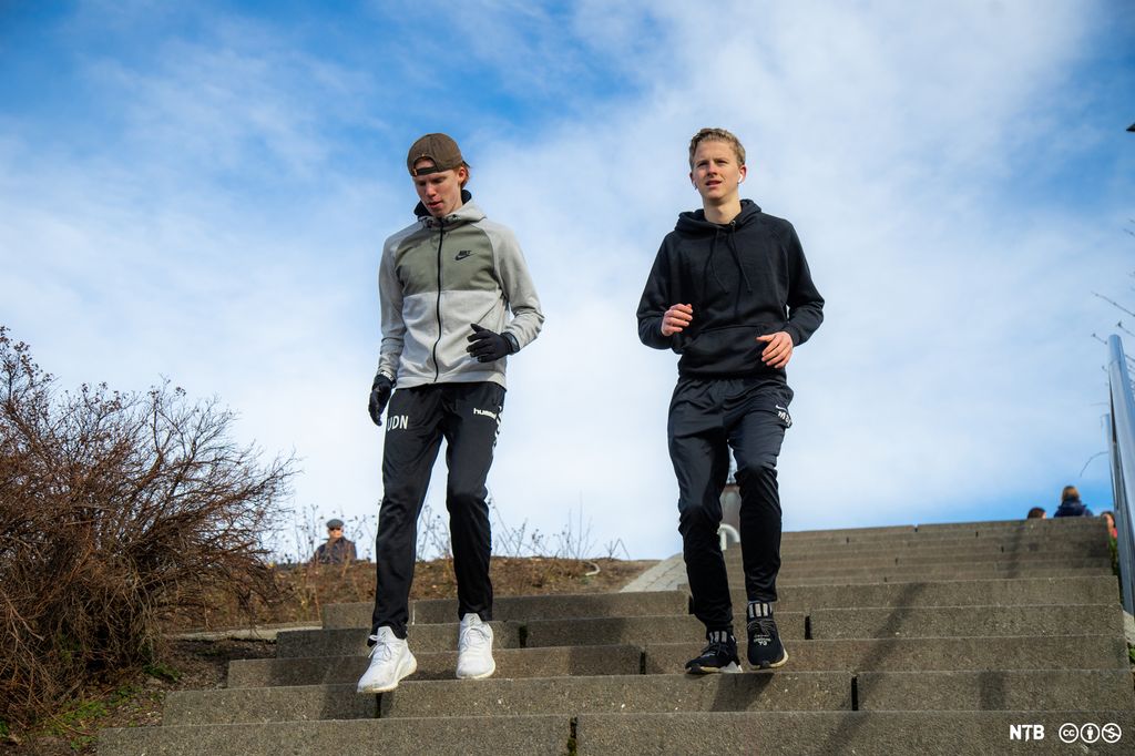 To ungdomar joggar ned ei trapp. Foto.