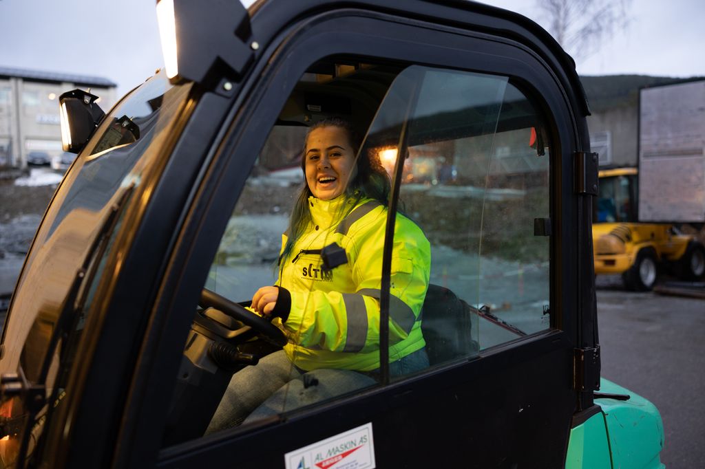Bildet viser en kvinnelig truckfører i en motvektstruck.