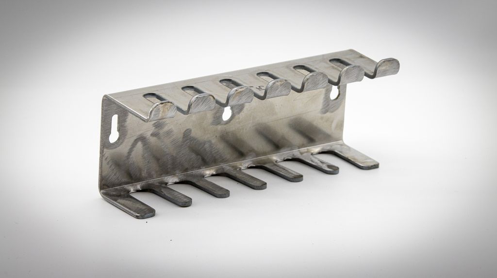 Metallstativ med seks slisser for oppheng. Foto.