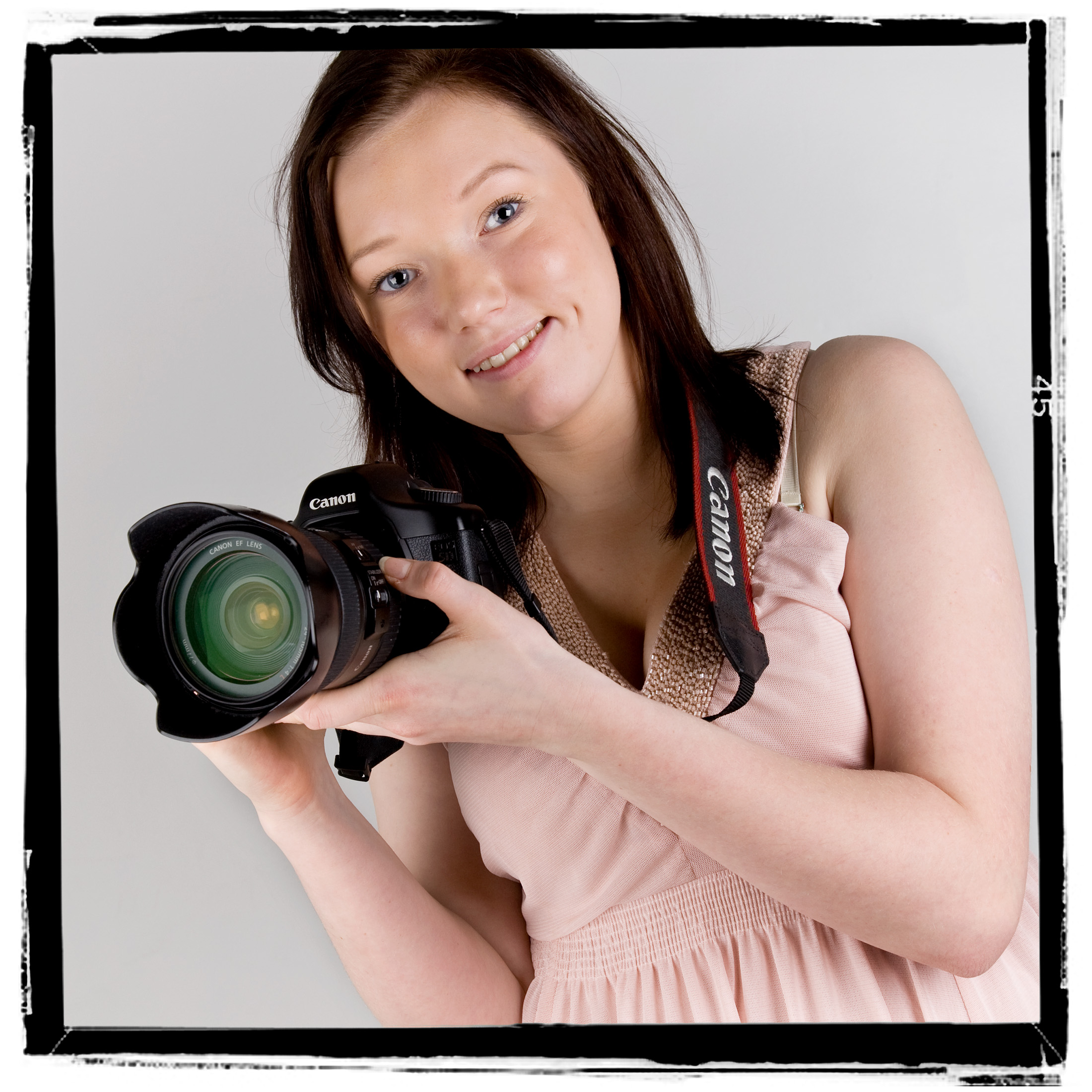 Jente holder et speilreflekskamera. Foto.