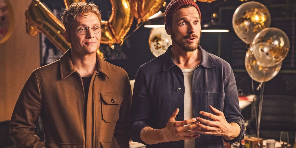 Toni og Paul, hovudpersonane i filmen "100 ting". Begge er uformelt kledde. Toni er lys i håret og har på seg briller med tynn metallinnfatning, og han smiler. Paul er mørk i håret og har skjegg, og han har lue på hovudet. Han ser noko spørjande ut. Foto.