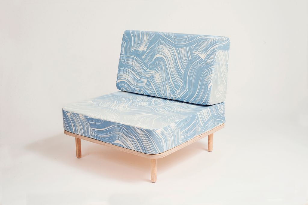 Blå og hvit stol med bein i lyst tre. Foto.