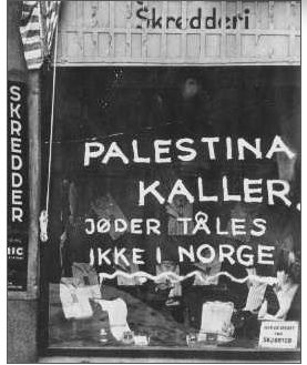 Jødehets måla på butikken til ein jødisk skreddar i Oslo i 1942. Teksten er: "Palestina kaller. Jøder tåles ikke i Norge". Foto. 