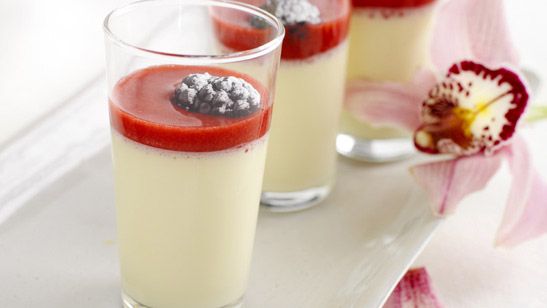 Glass med panna cotta og bringebærsaus. Foto.