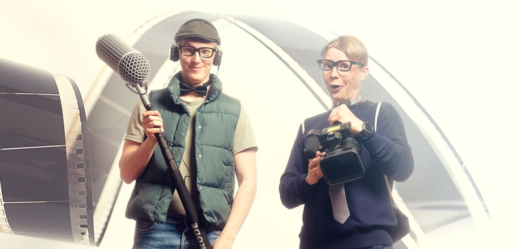 To gutter på rundt 18–19 år. Den ene holder en mikrofonbom, den andre et kamera.  Begge bruker briller med svart innfatning. Ellers er de pent, men uformelt kledd og ser glad ut. Foto.