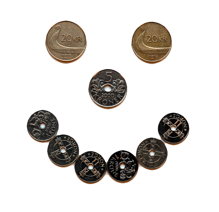 Mynter som former et smilefjes. To tjuekronemynter er øynene, en femmer er nesen, og seks kronestykker er munnen. Foto.