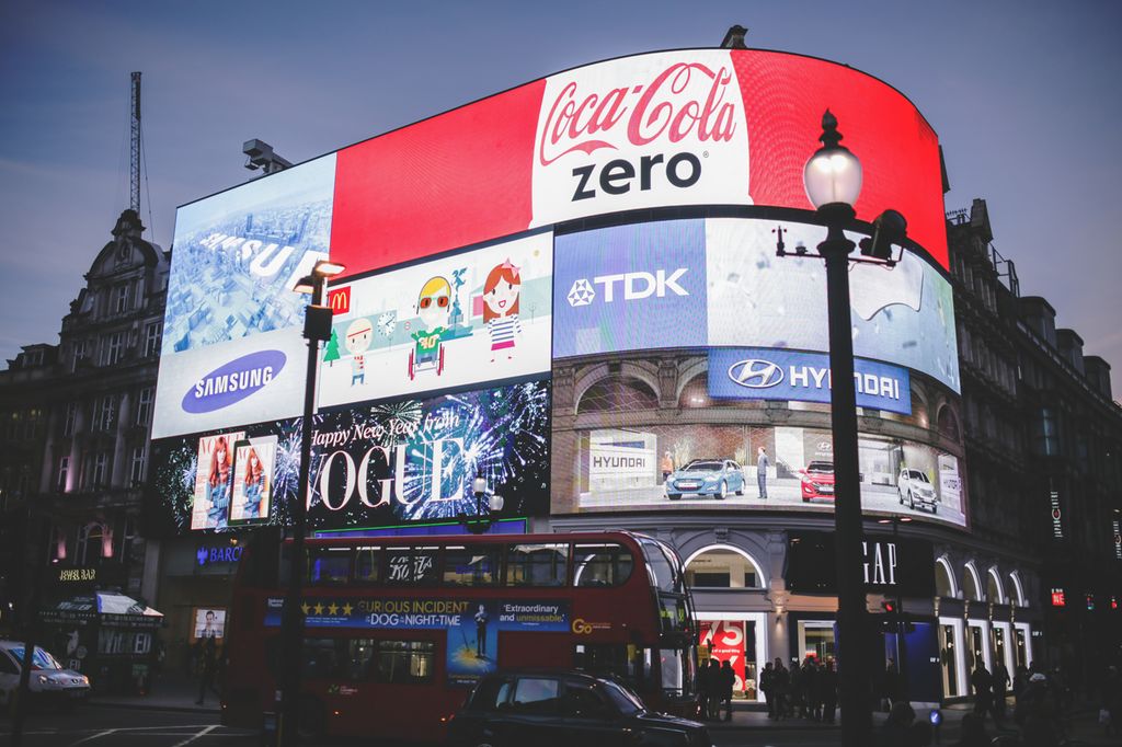 Piccadilly Circus i London på kveldstid, med logoer og reklameskilt. Foto.