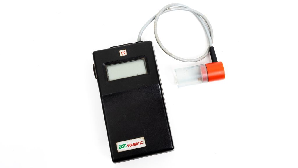  Svart apparat med display. På toppen går det ut en ledning med en sonde i enden. Foto.