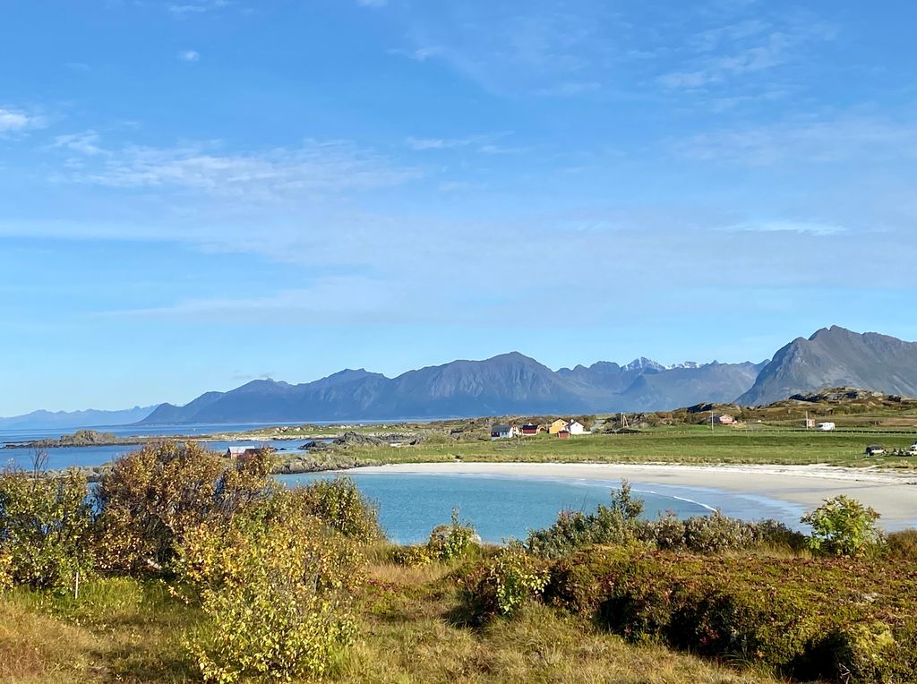 Photo: Landscape with mountains, ocean and a sandy beach. 