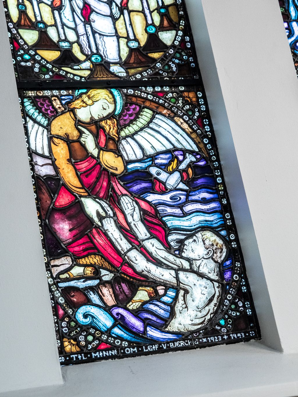 Detalj frå eit glasmaleri som viser ein flystyrt. Foto.