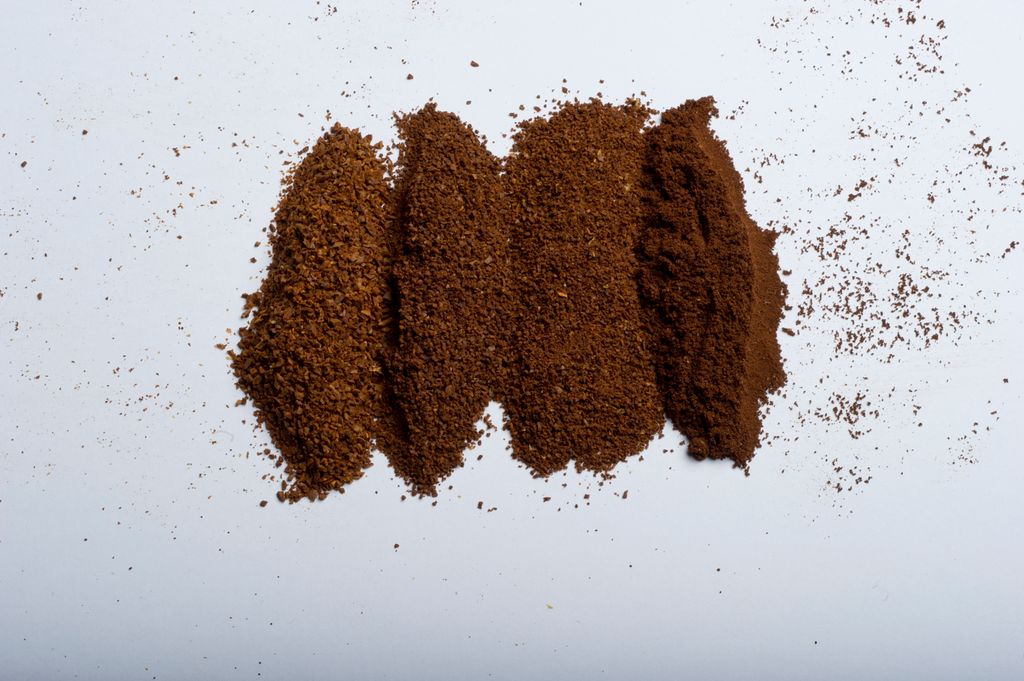 Hauger med kaffe malt i ulike malingsgrader på en rekke. Foto.